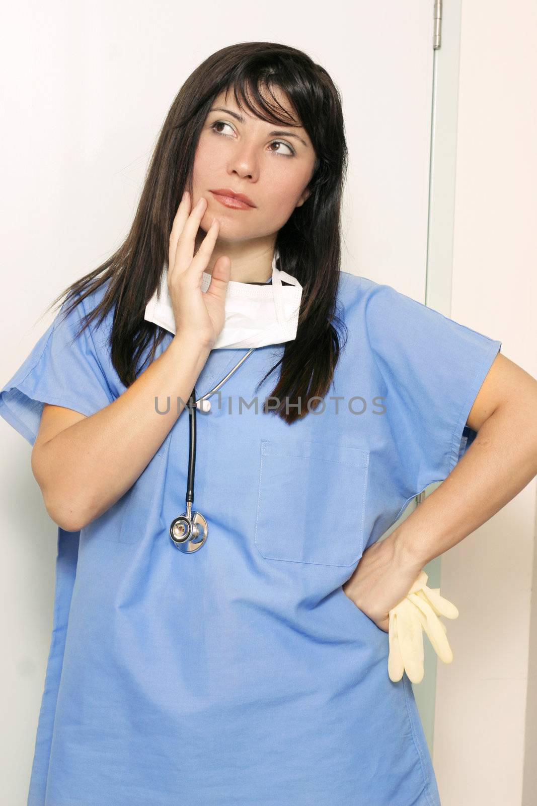 Nurse standing with hand on hip and thinking or making an assumption
