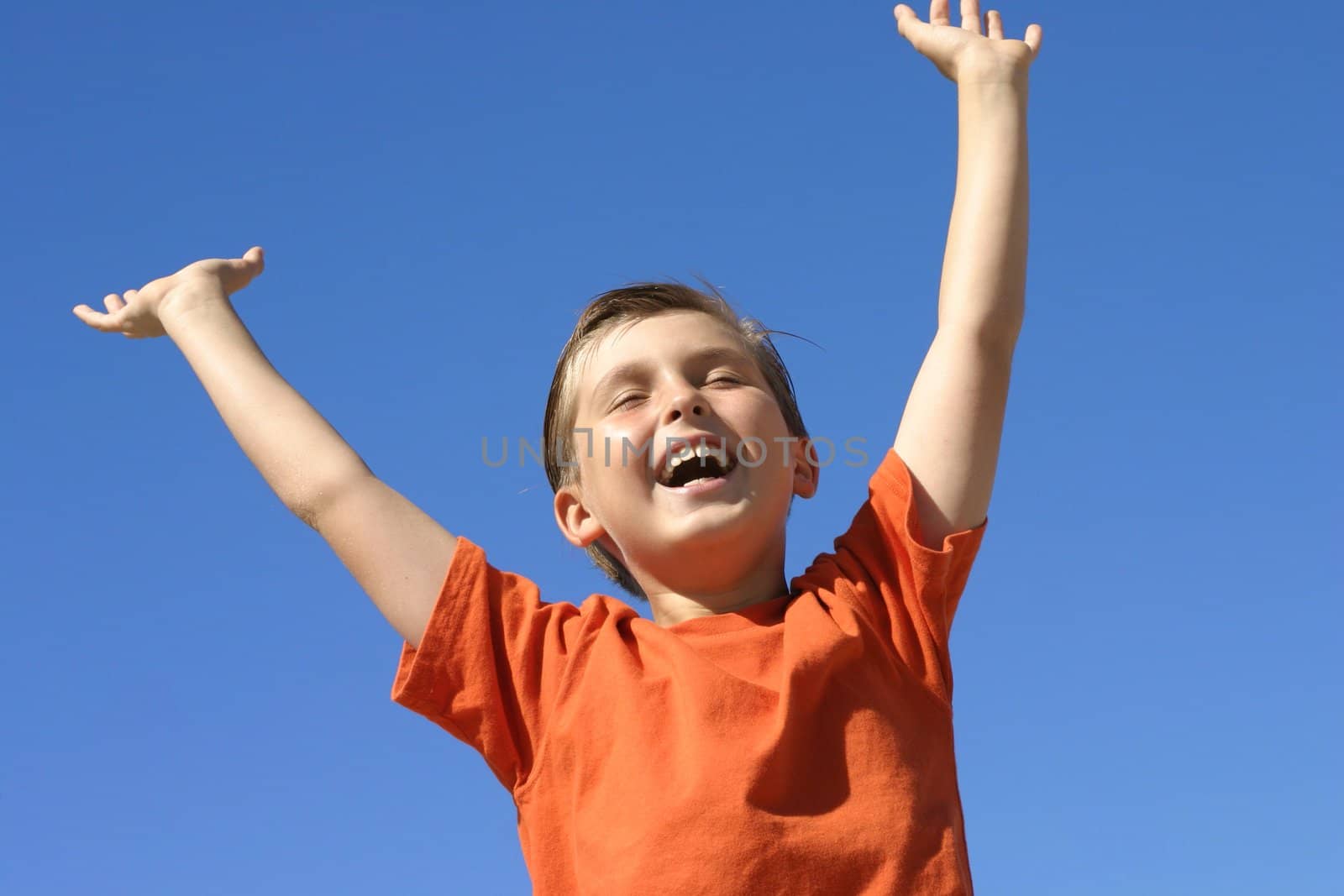 A boy shows joy, success praise or triumph