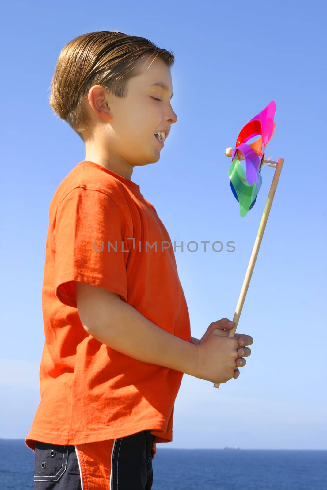 A child with a spinning pinwheel on a bright beautiful day