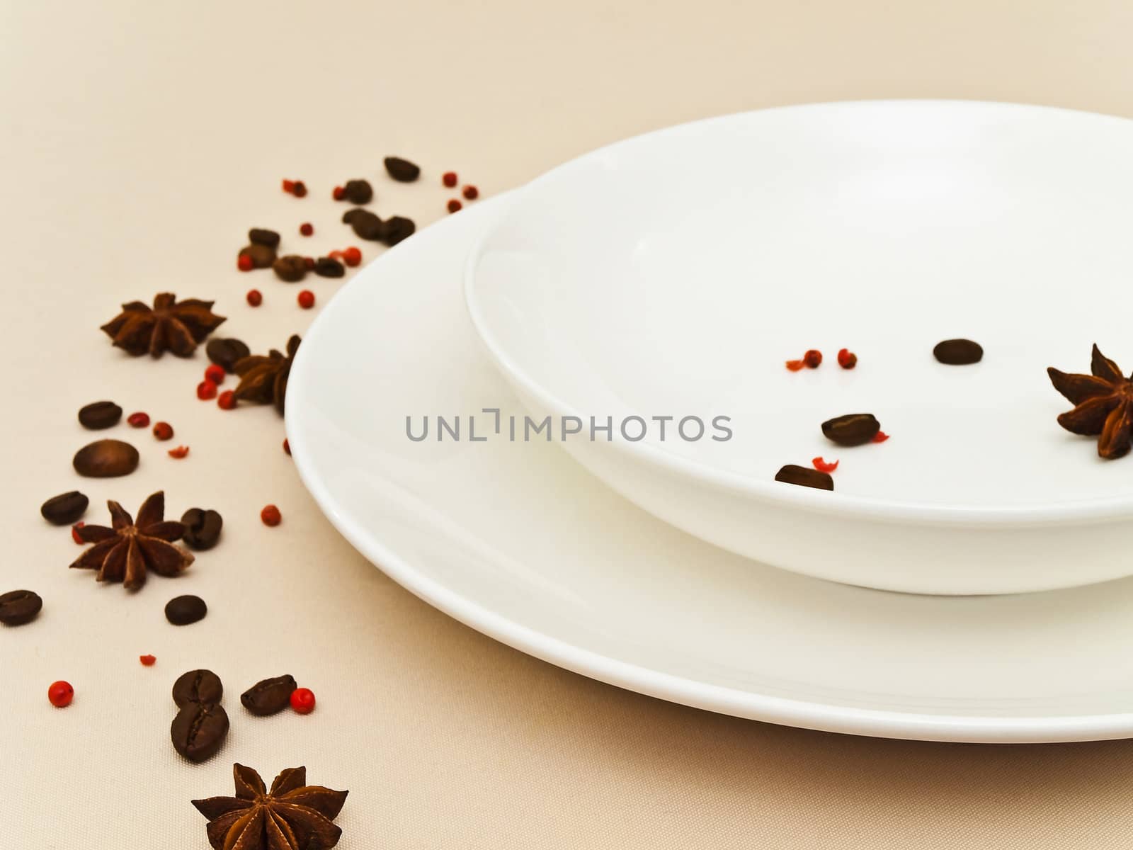 table serving with  anise stars, red pepper and coffee beans at beige tablecloth