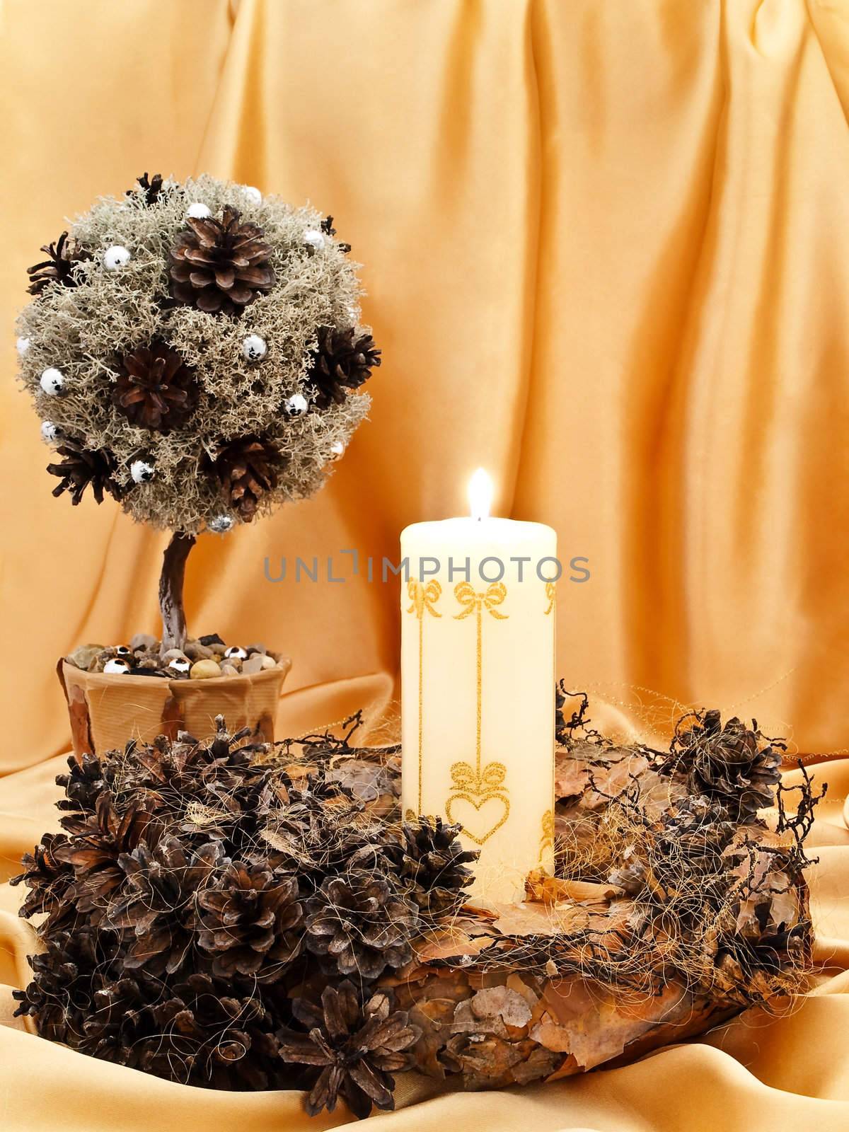 handmade garland, decorative little tree with candle against golden textile background