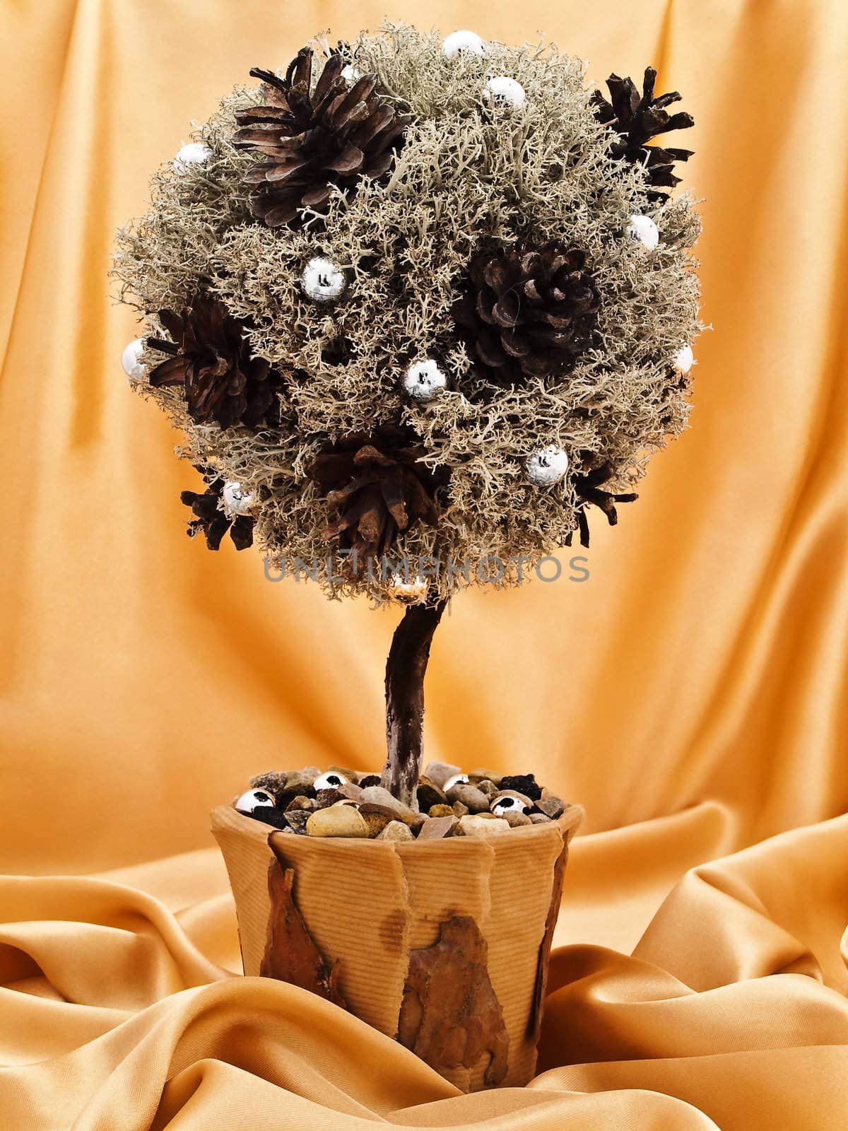 single decorative handmade natural materials tree against the golden textile background 