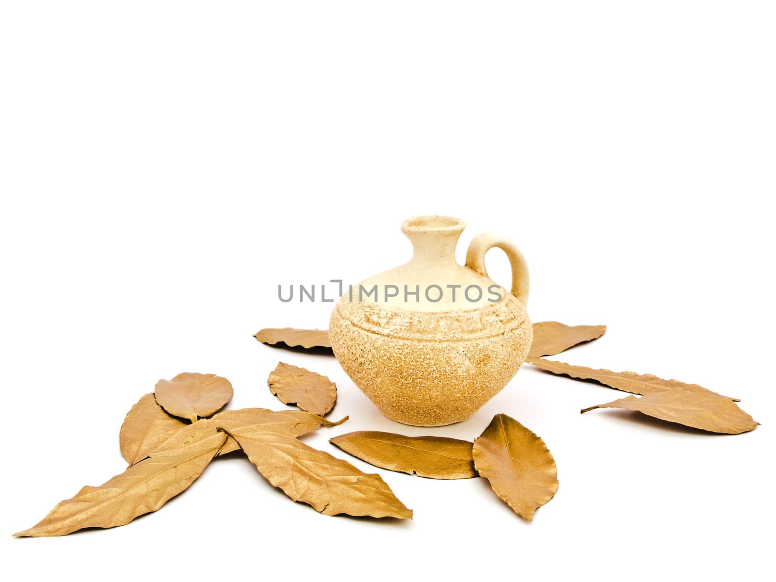 Photo of ancient beige vase and golden bay leaves against white background 