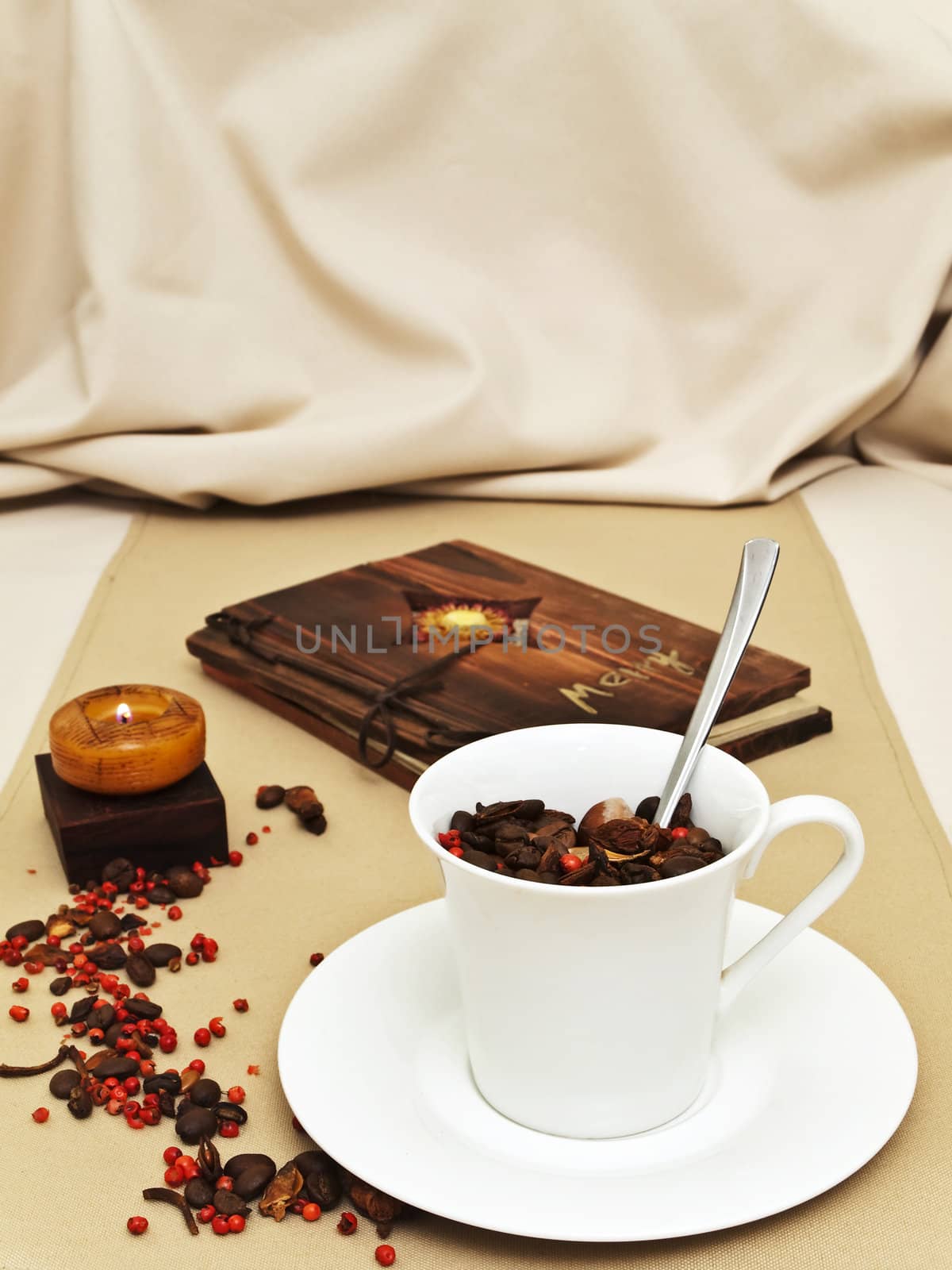 decorated table serving with burning candle and coffee beans aroun the cup 