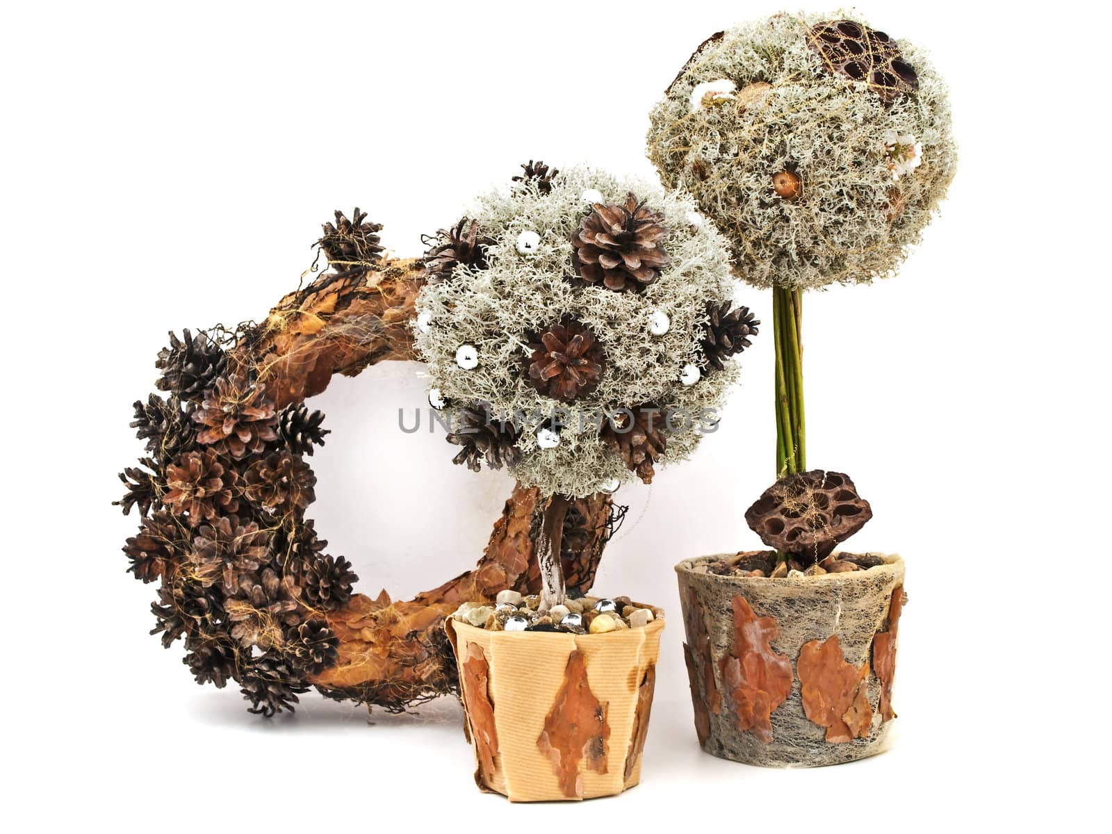 Handmade decorative trees from pine tree and cones with wreath against the white background 