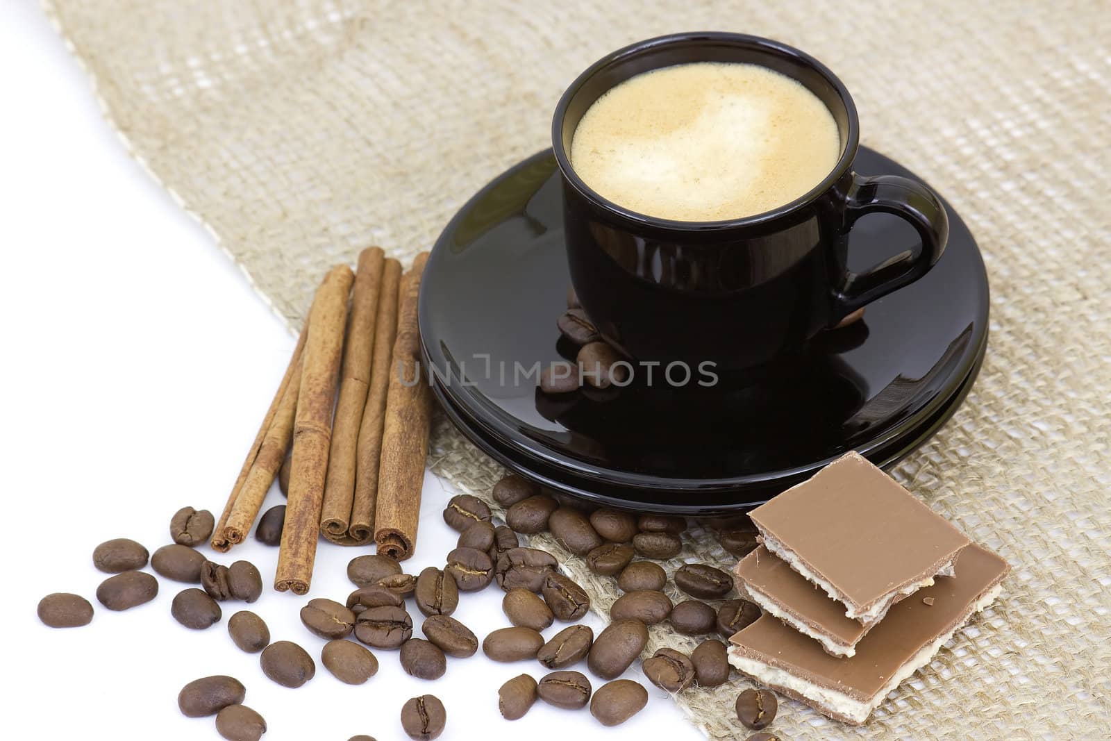 cup of italian espresso with cinnamon, coffee beans and chocolate