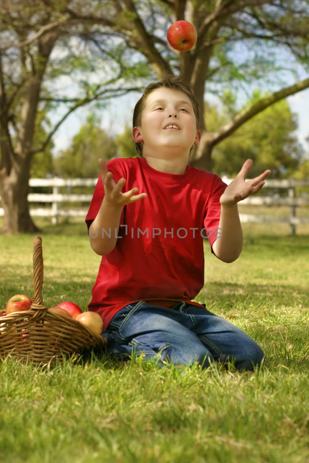 A child throwing and catching a red apple