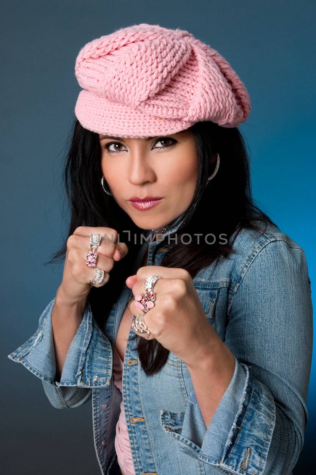 A beautiful and fashionable female with a fistful of jewellery - hands in a boxing position.