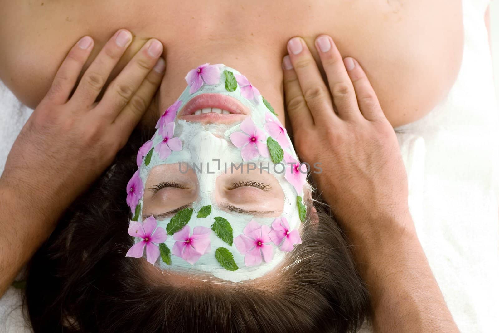 A woman enjoys a therapeutic neck massage during a facial treatment 
- landscape