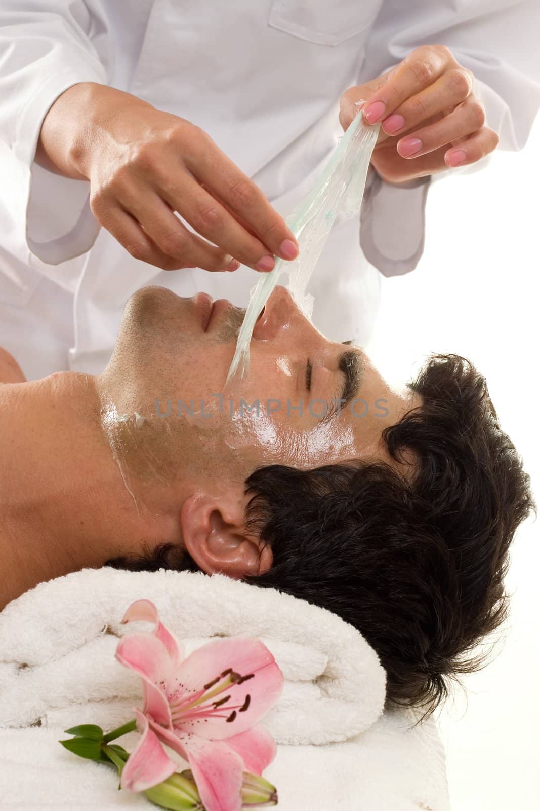 Facial Peel - A beautician performs a facial peel on a male client.