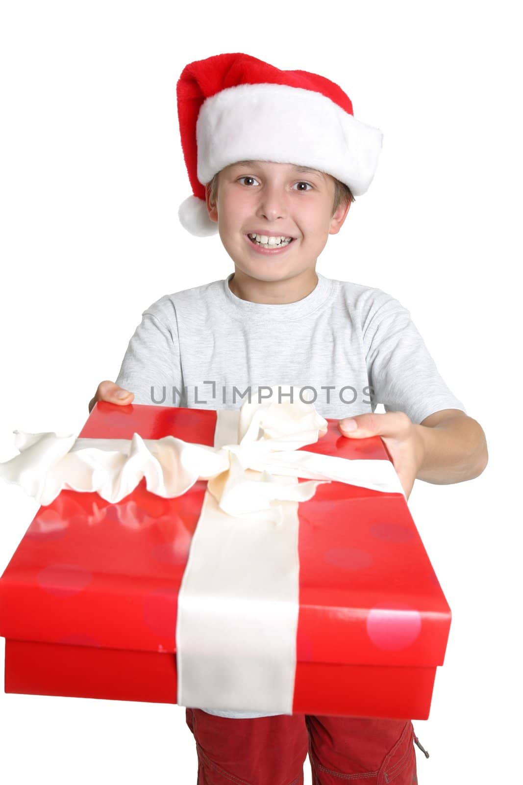 A boy gives someone a Christmas present. Focus on boy.