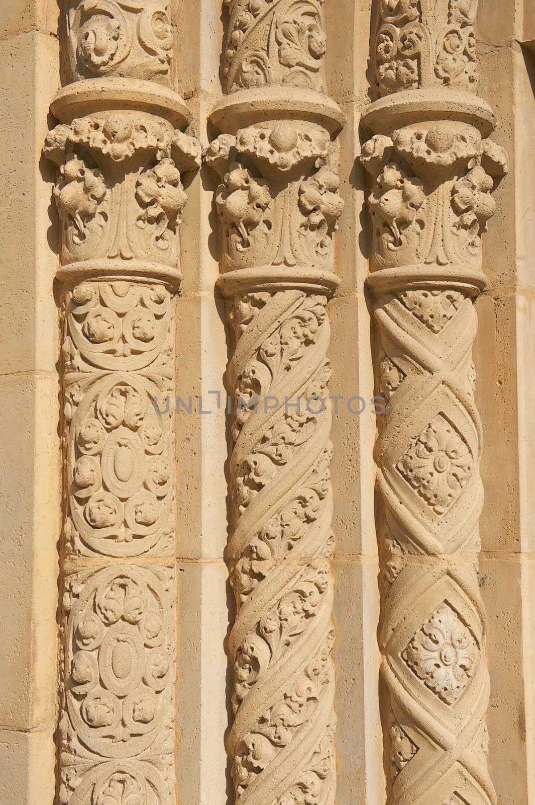 The Three Ornate, Circular, Old Pillars standing straight in a row made of stucco