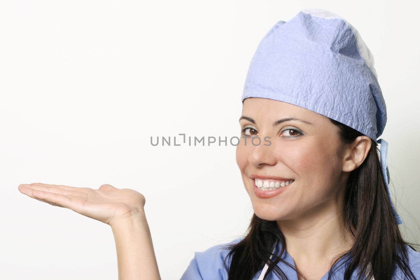 A female in medical unform with hand outstetched palm upwards ready for a product display, or other.