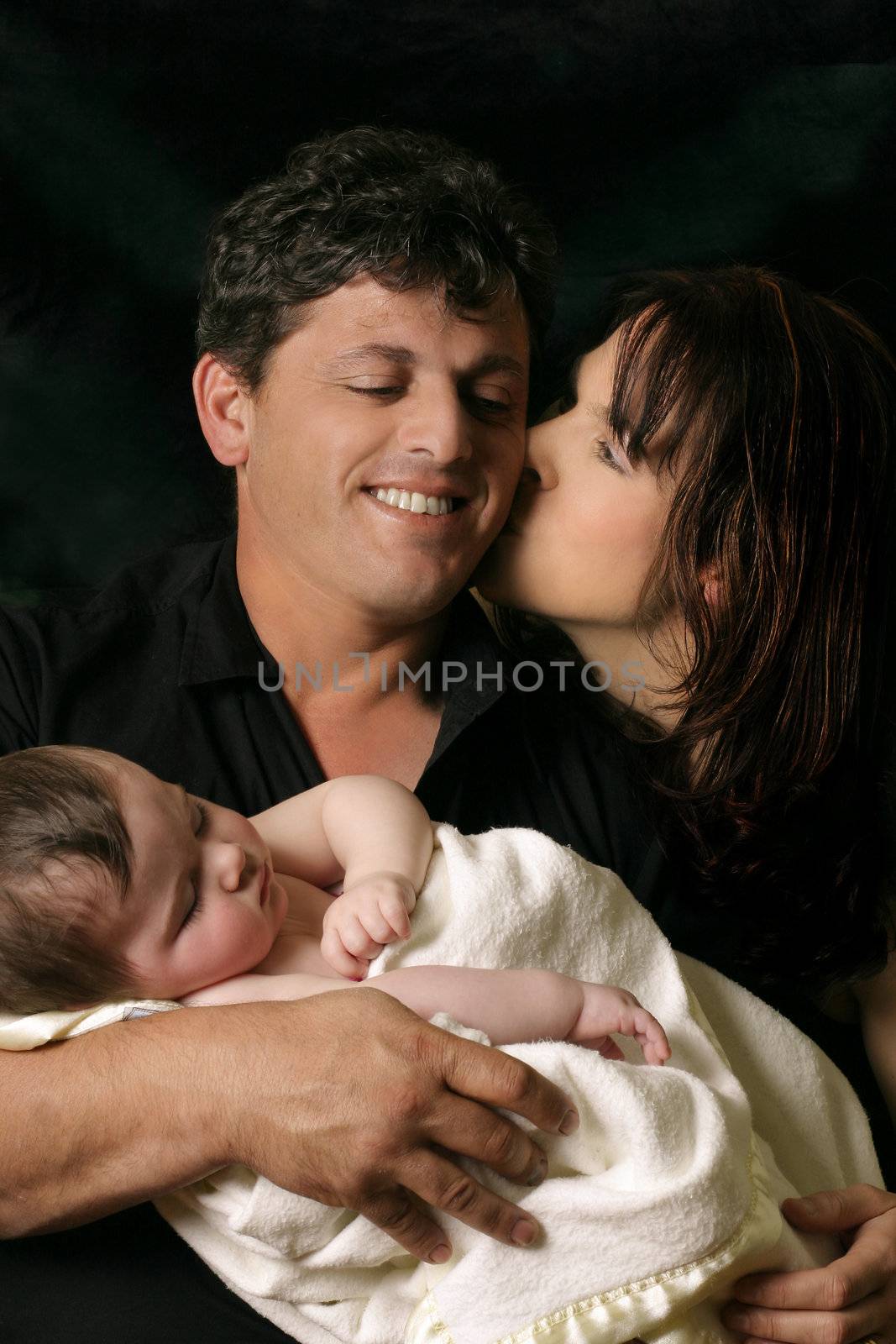 Affectionate parents holding newborn child