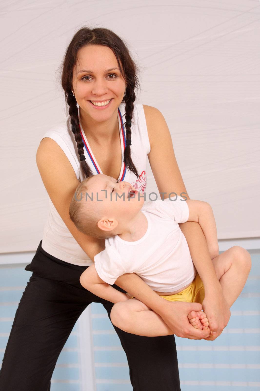 Mum with the son play a sports hall
