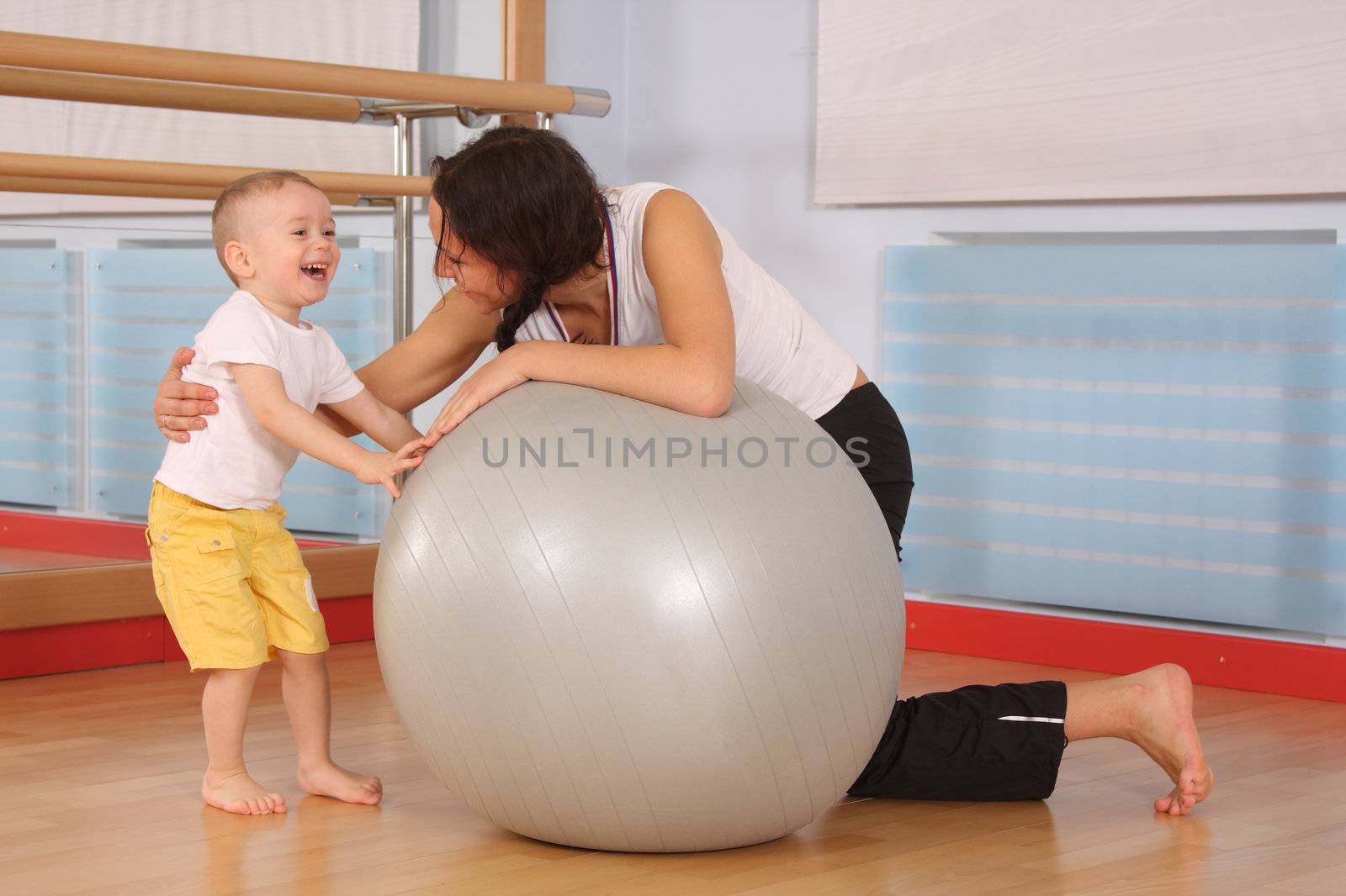 Mum with the son play a sports hall
