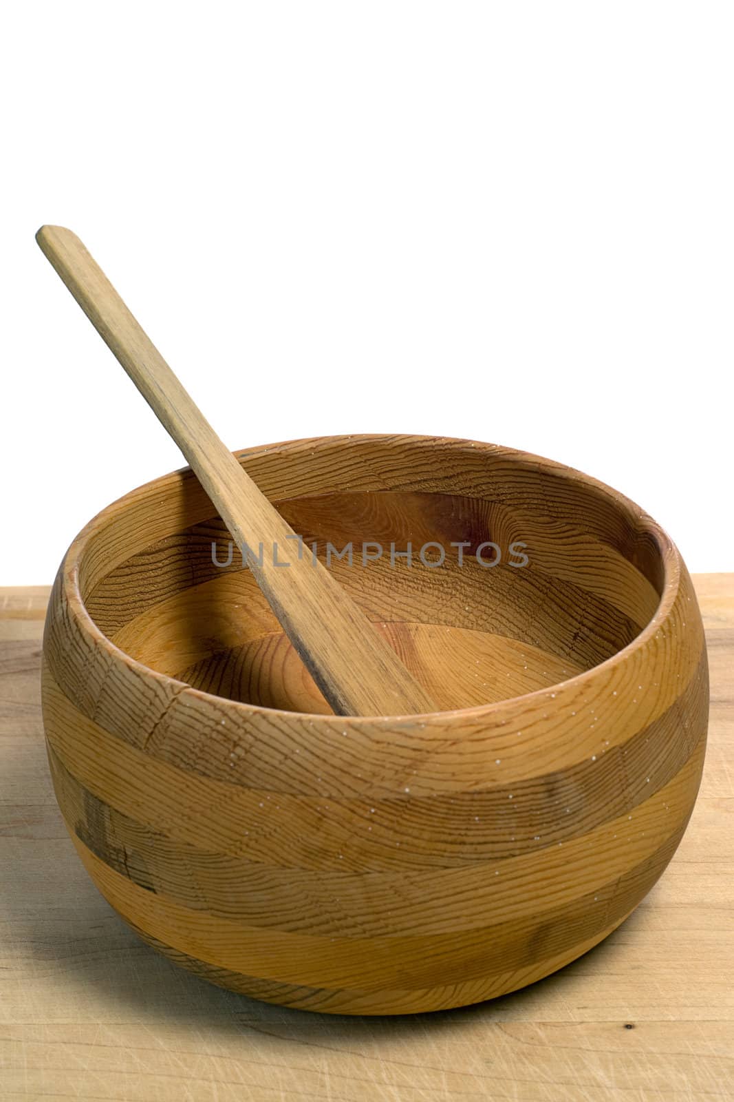 A small wooden bowl with a spatula in it, isolated against a white background