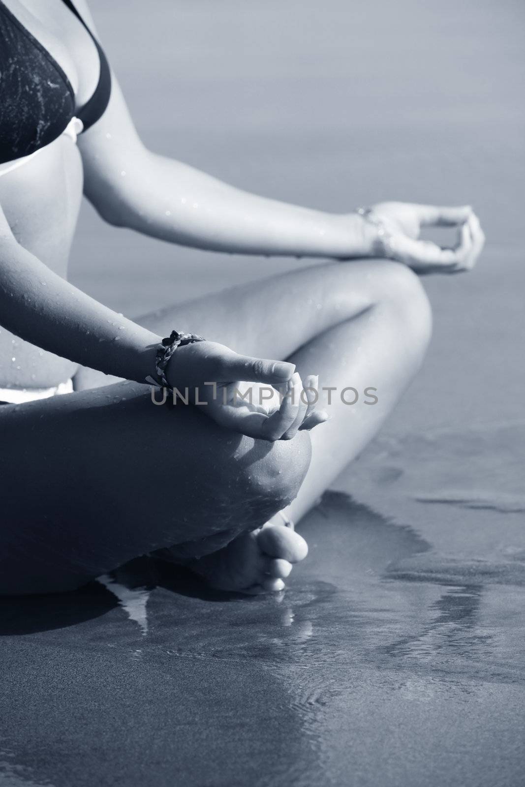 A woman is meditating by the coast ocean