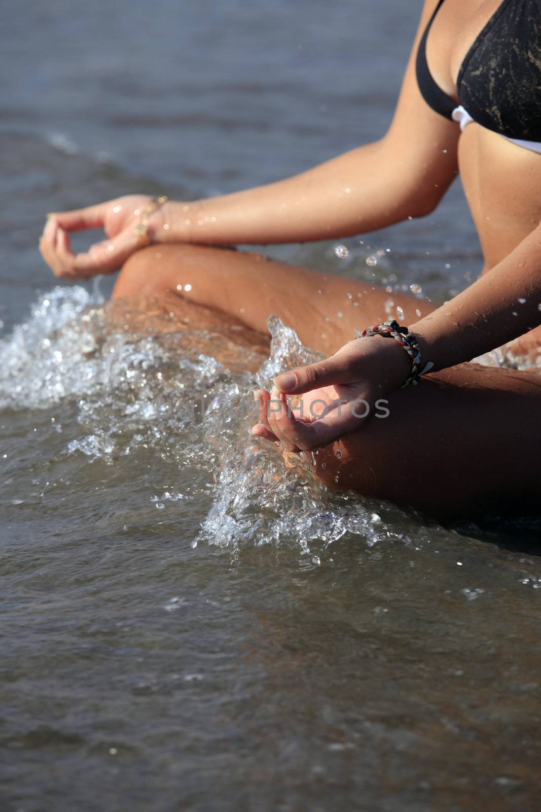 A woman is meditating by the coast ocean