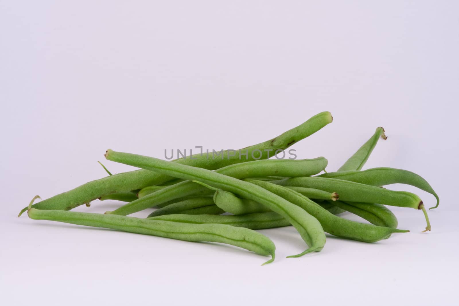 Fresh organic French green beans on white.