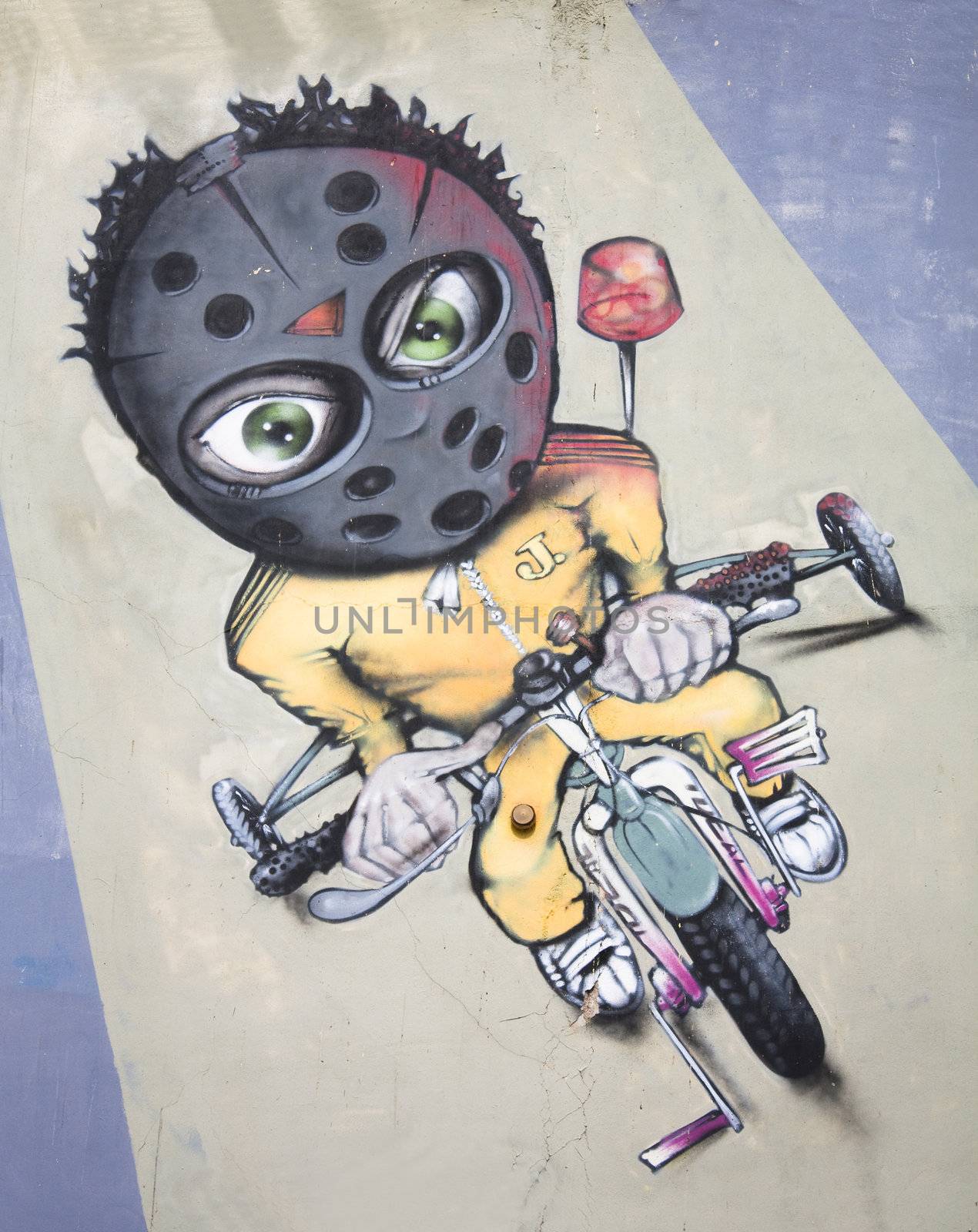 Graffiti in Athens showing a youngster riding a bike with a helmet on.
