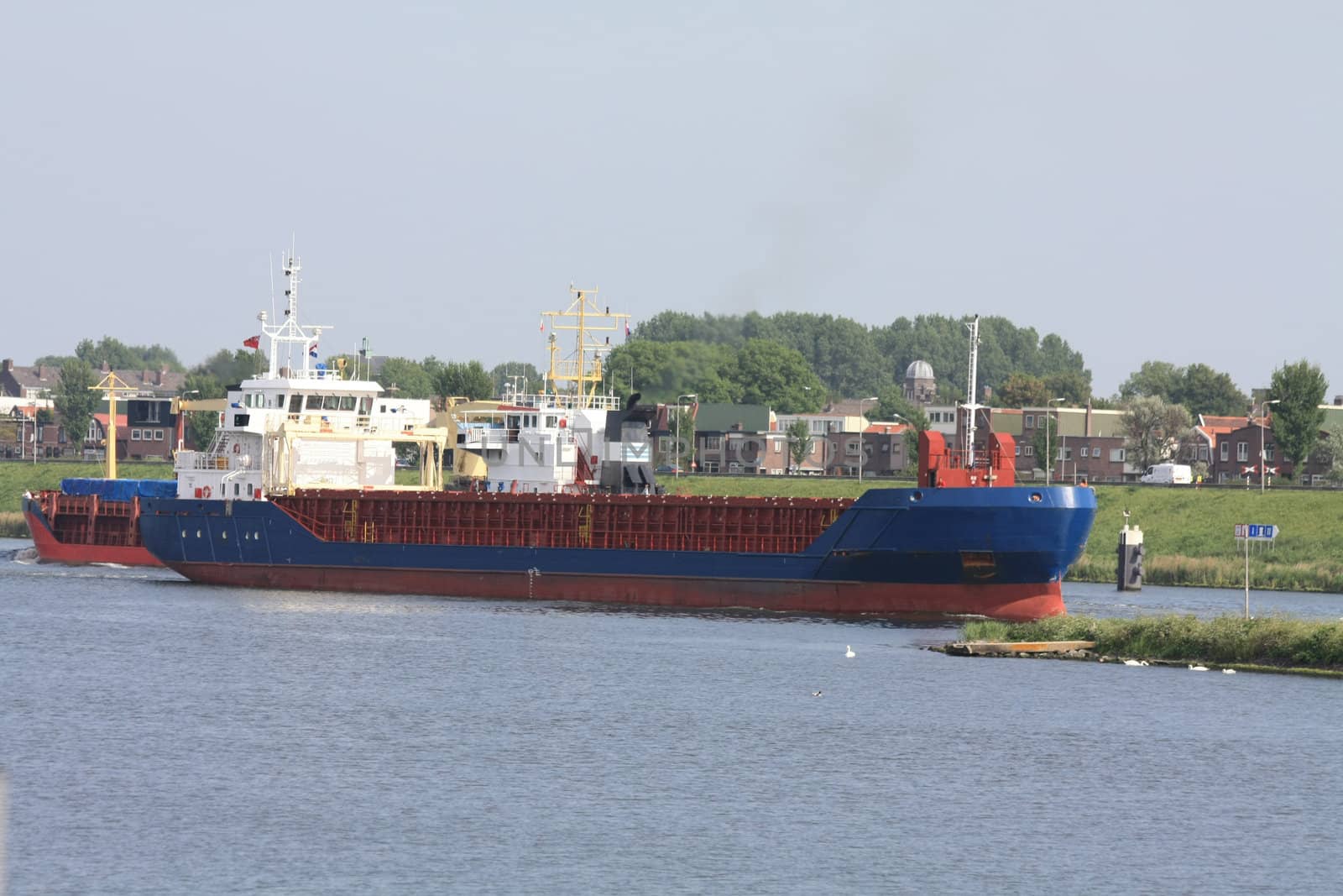 Middle size ship transporting containers over a canal