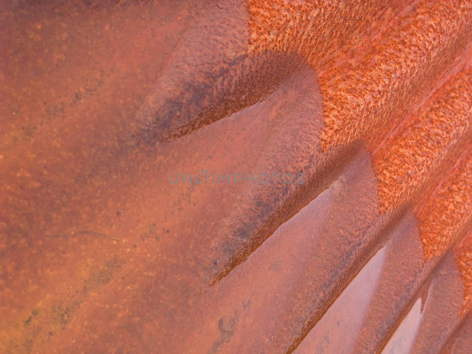 Rust and water combine on corrugated iron.