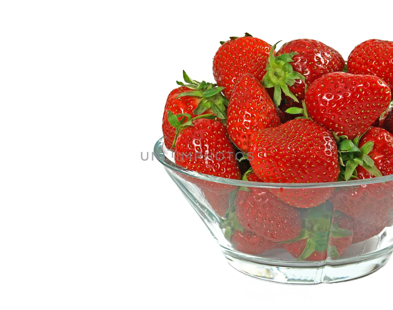fresh and juicy strawberries on glass bowl over white