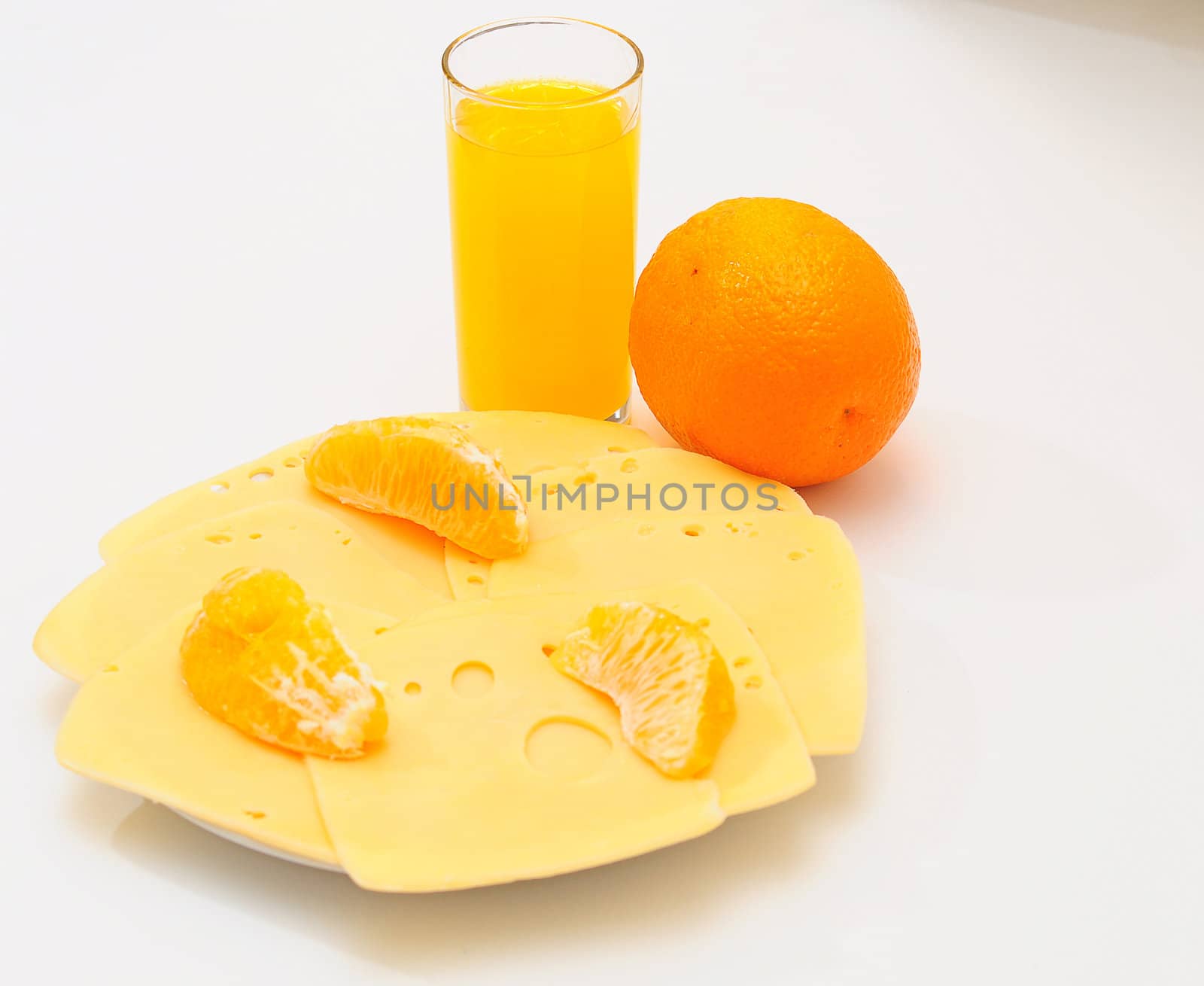 Yellow cheese  on the  plate.Orange juice in a glass.