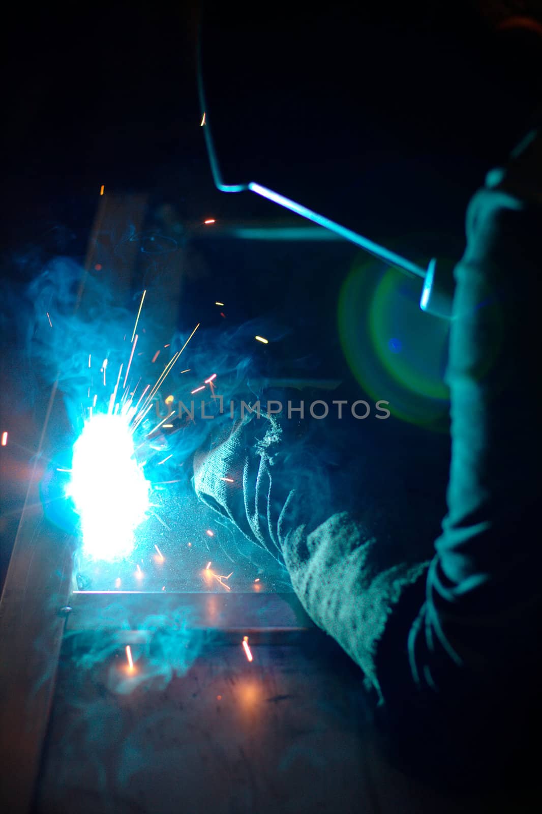 Close-up photo of a welder at work with sparks flying around