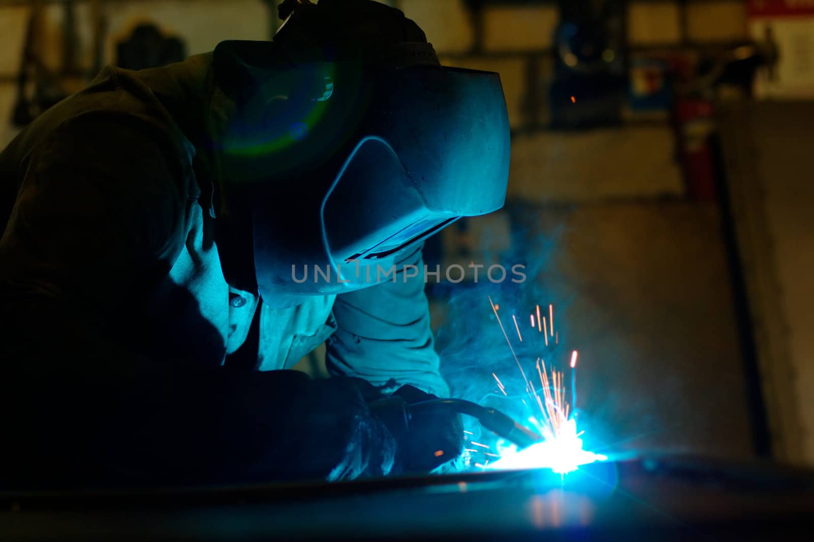 Close-up photo of a welder at work with sparks flying around