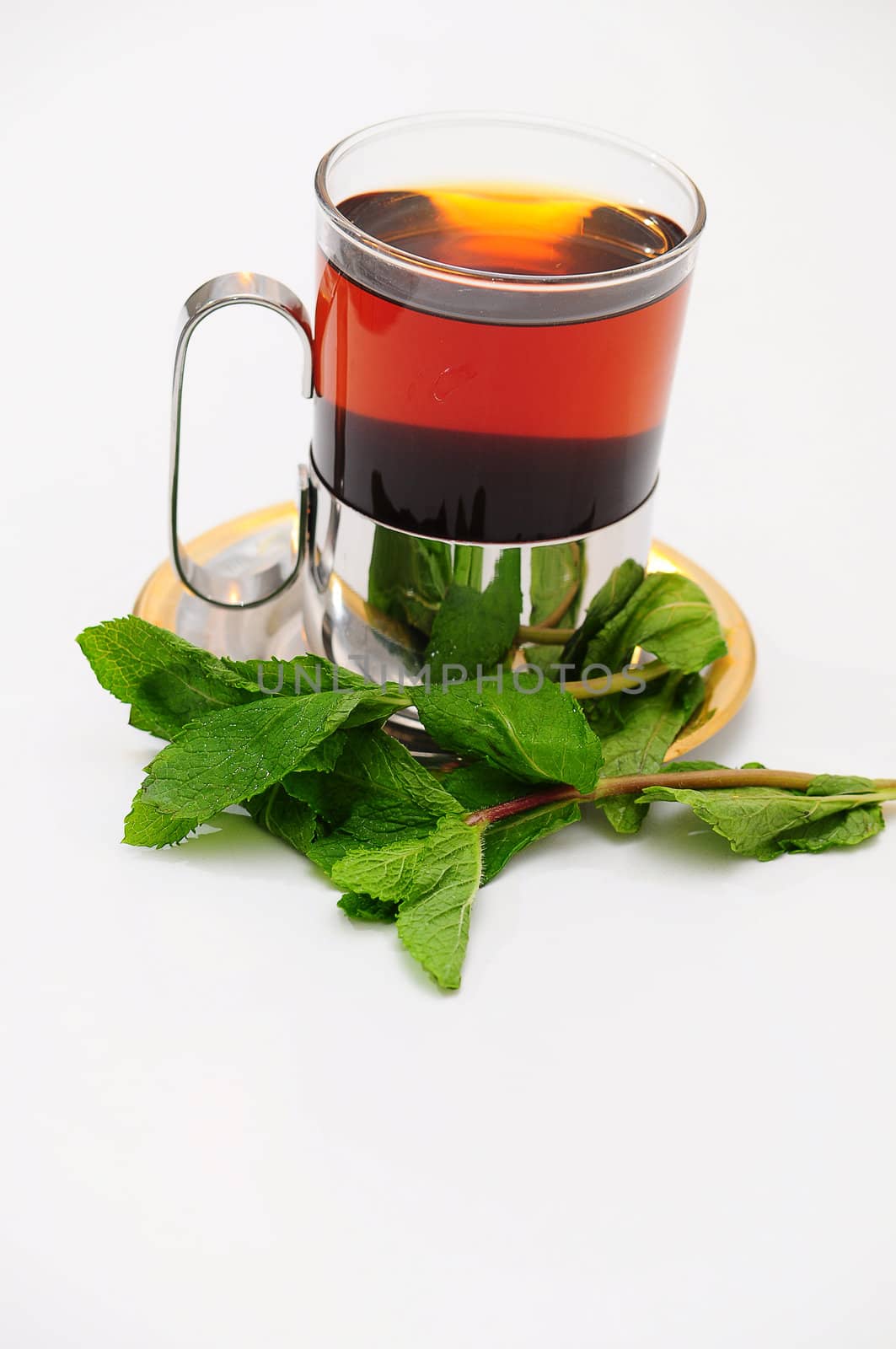 A glass of hot tea on a saucer.