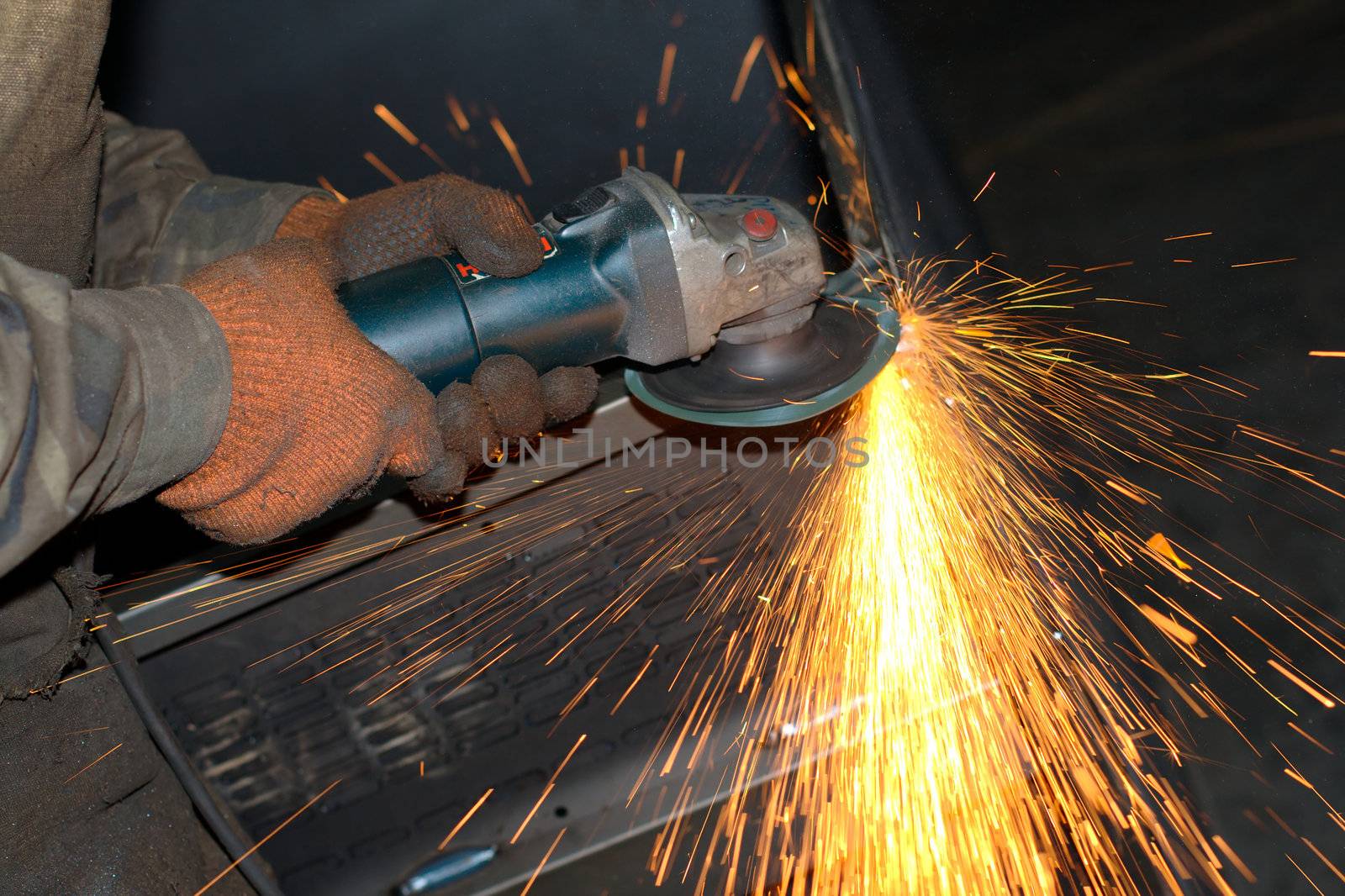 Close-up photo of an electric grinder with sparks flying around