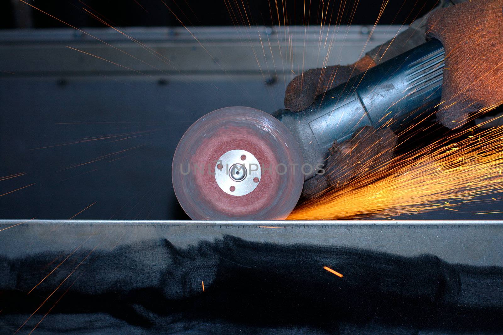 Close-up photo of an electric grinder with sparks flying around