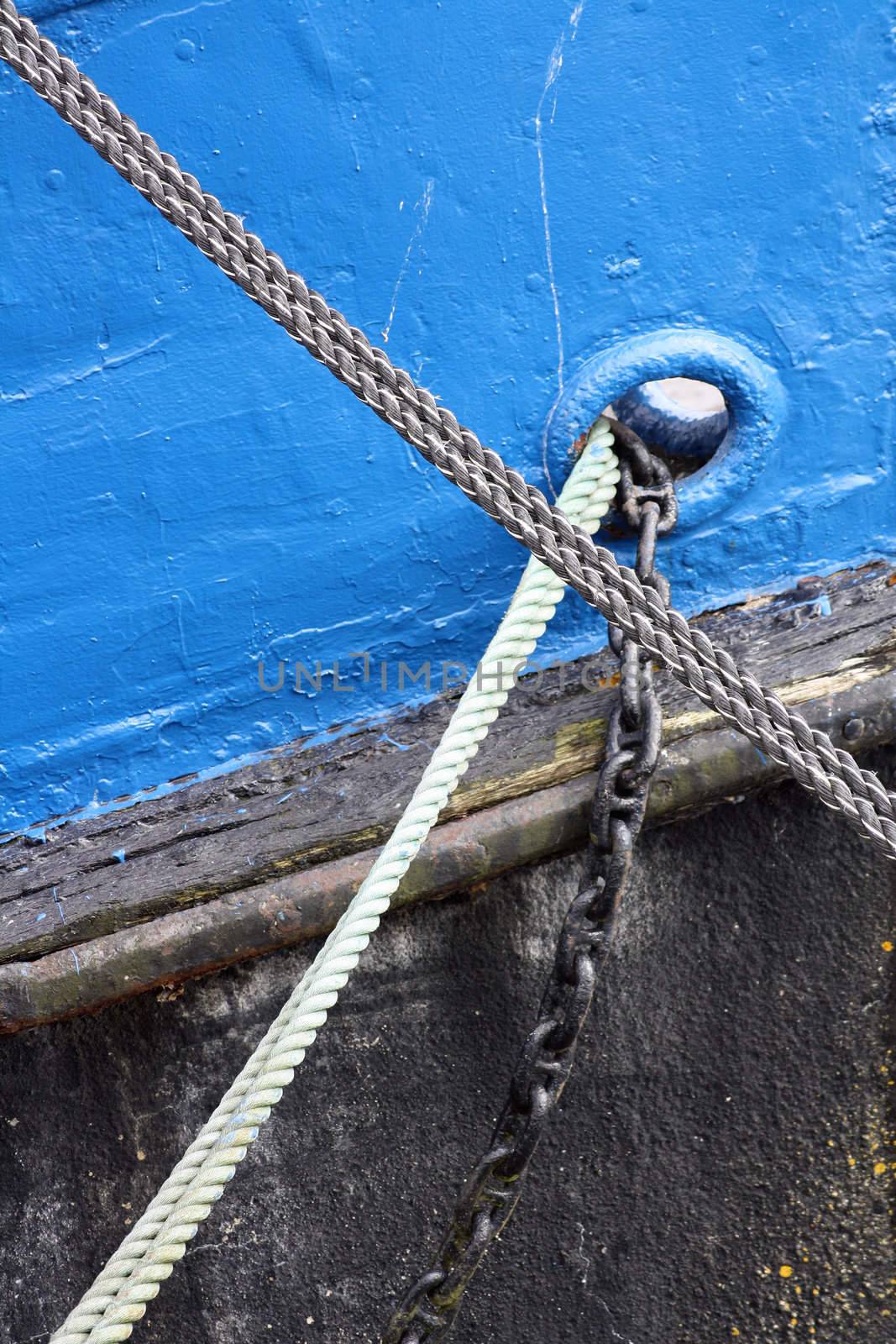 Maritime abstract. Detail of a ship's bow in Husum harbour. Ropes and a chain.