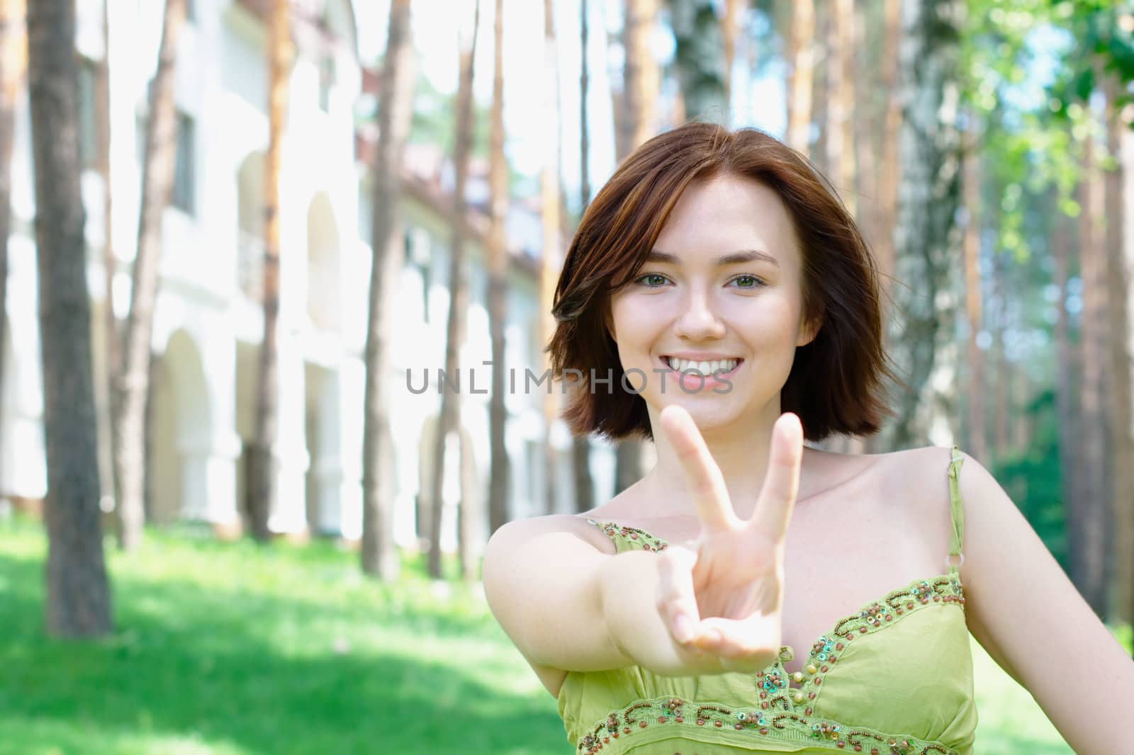 Close-up portrait of a girl with a victory sign
