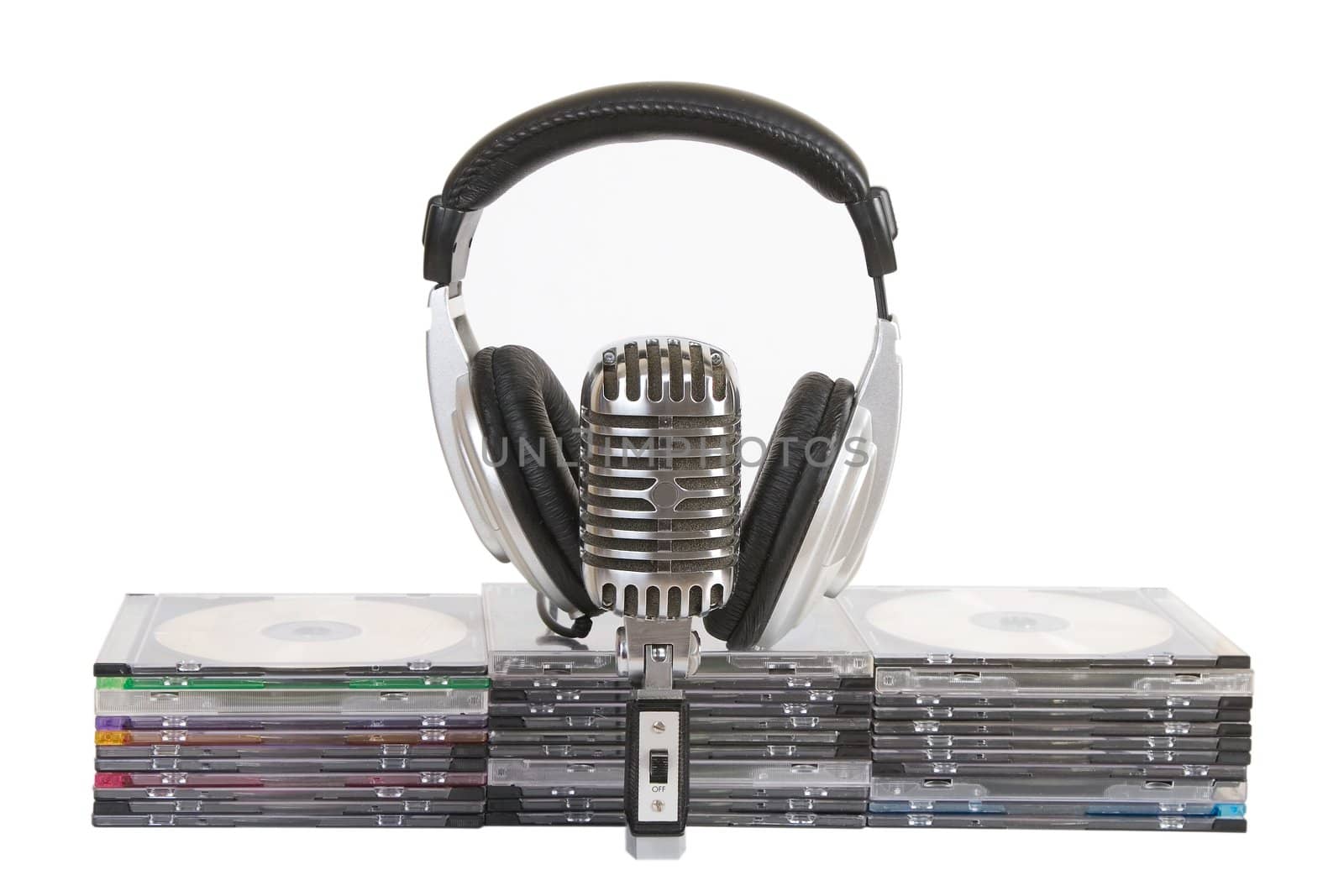 Front view of headphones, vintage microphone, cd, dvd stack