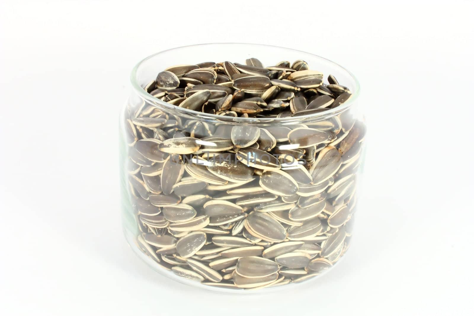 Glass jar full of  unshelled sunflower seeds, isolated on white