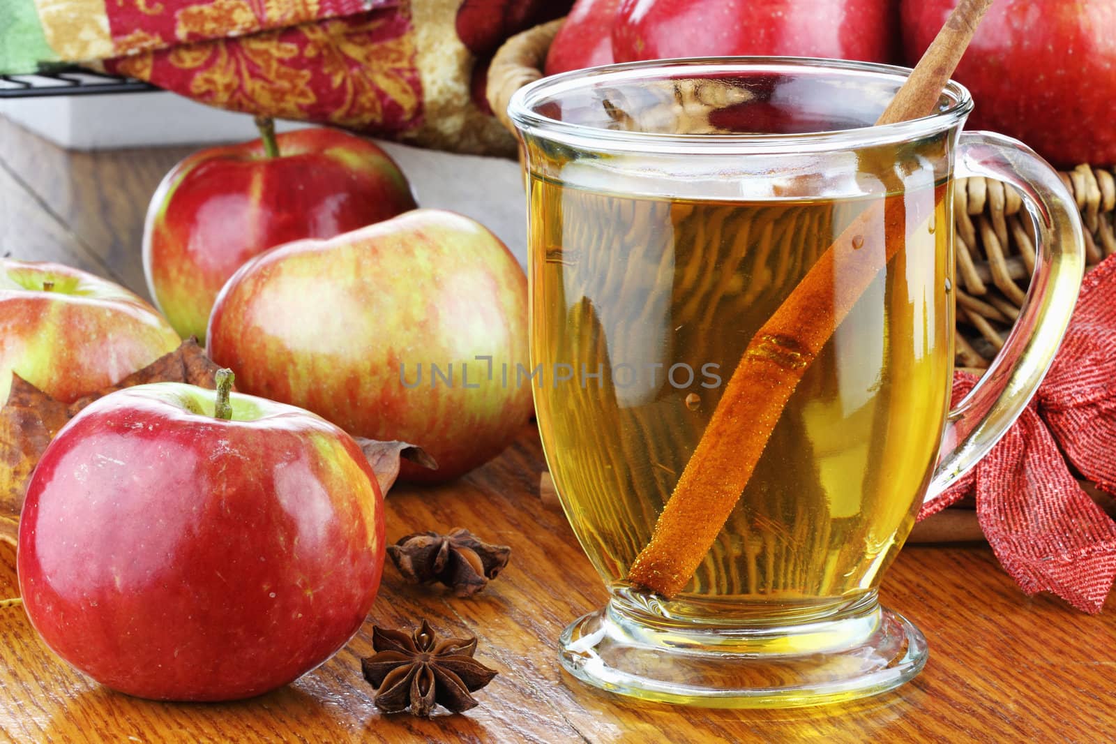 Apple Juice with cinnamon bark, anise stars and fresh apples. Shallow depth of field with selective focus on juice. Reflection can be seen in table.
