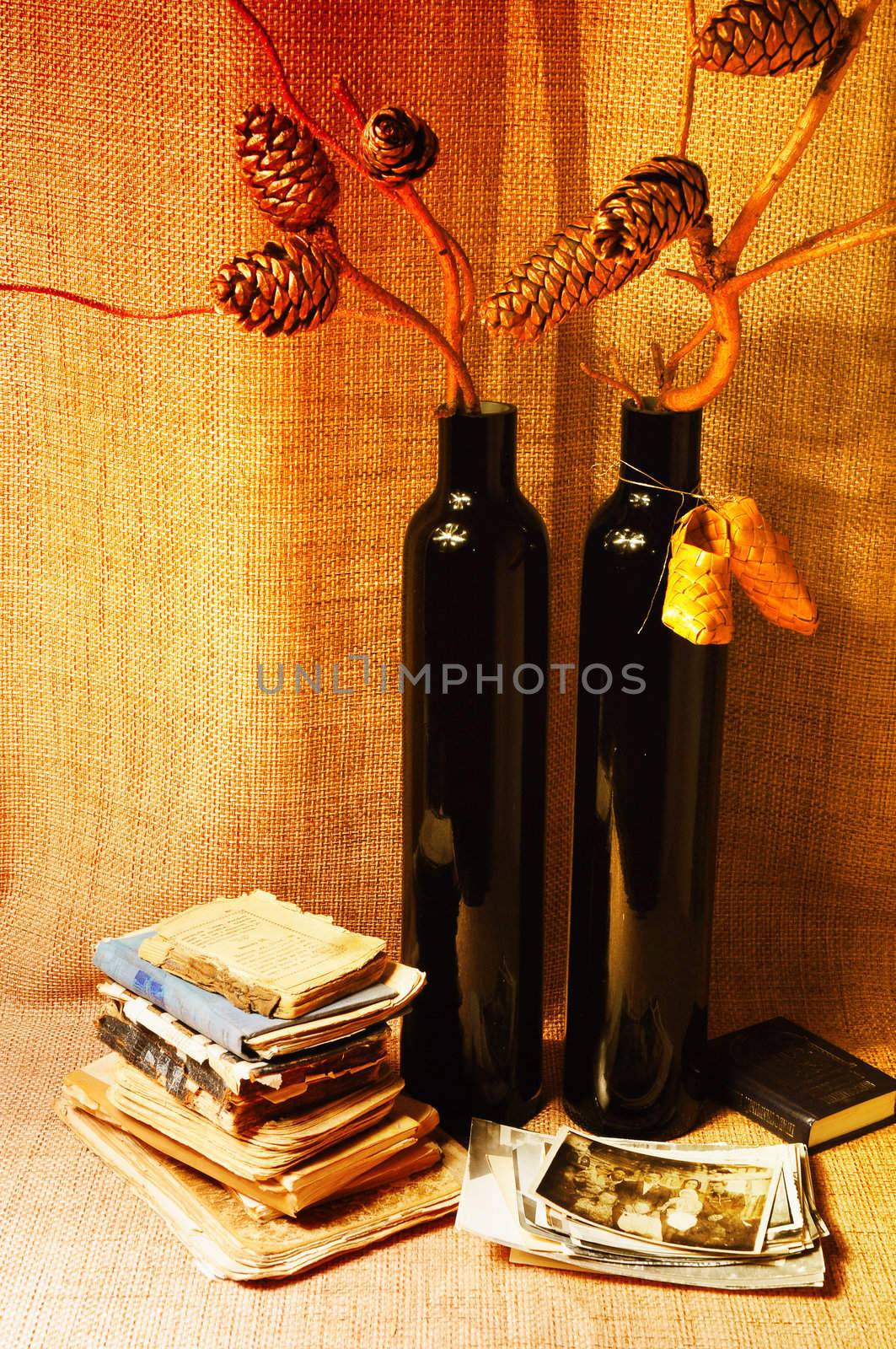 Forest composition. Vase with bronze fir branches , books and photos  on sacking.

