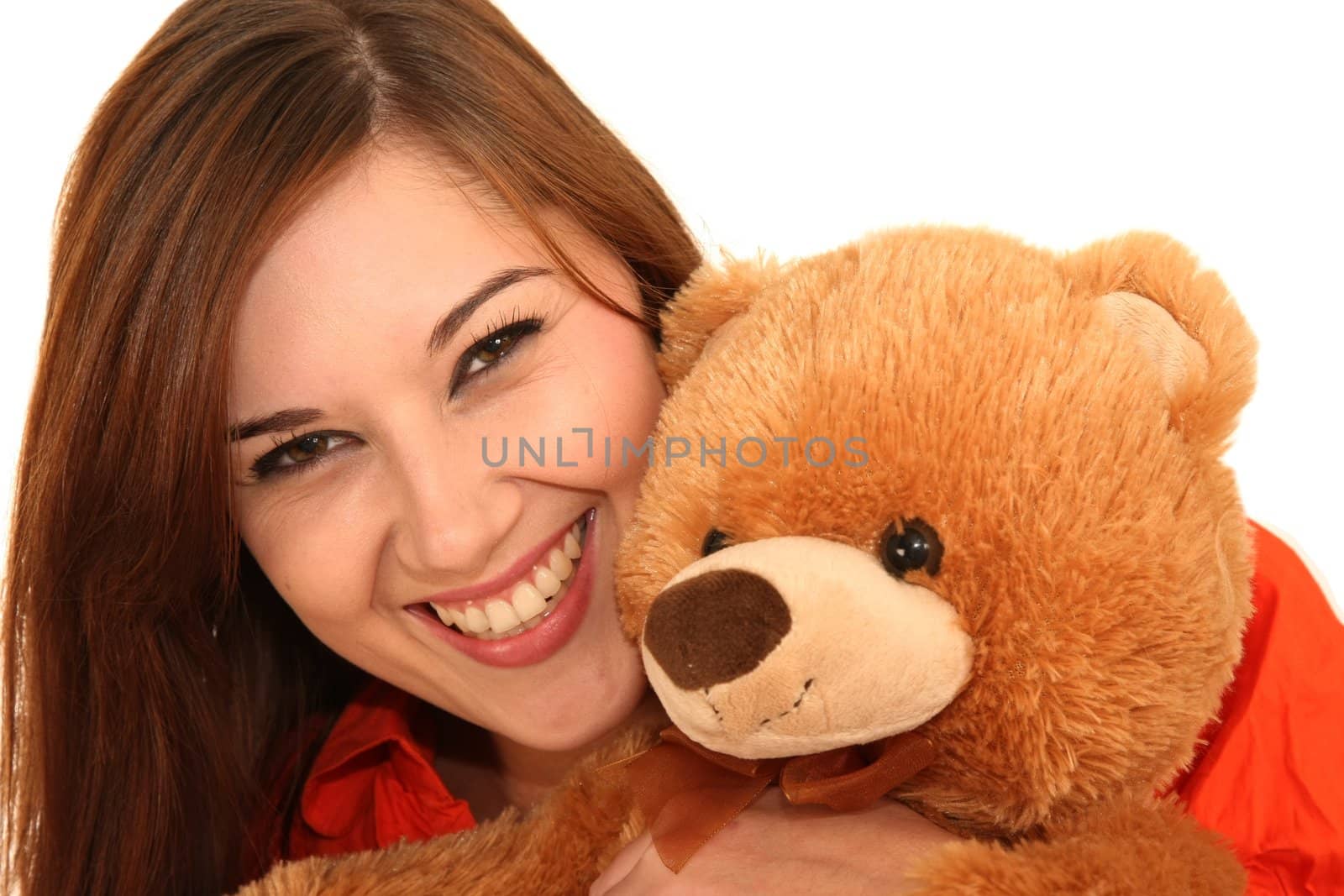 Beautiful smiling brunette girl hugging her stuffed bear