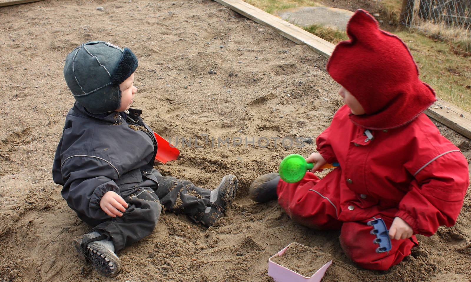 Child playing happily with sand in kindergarten