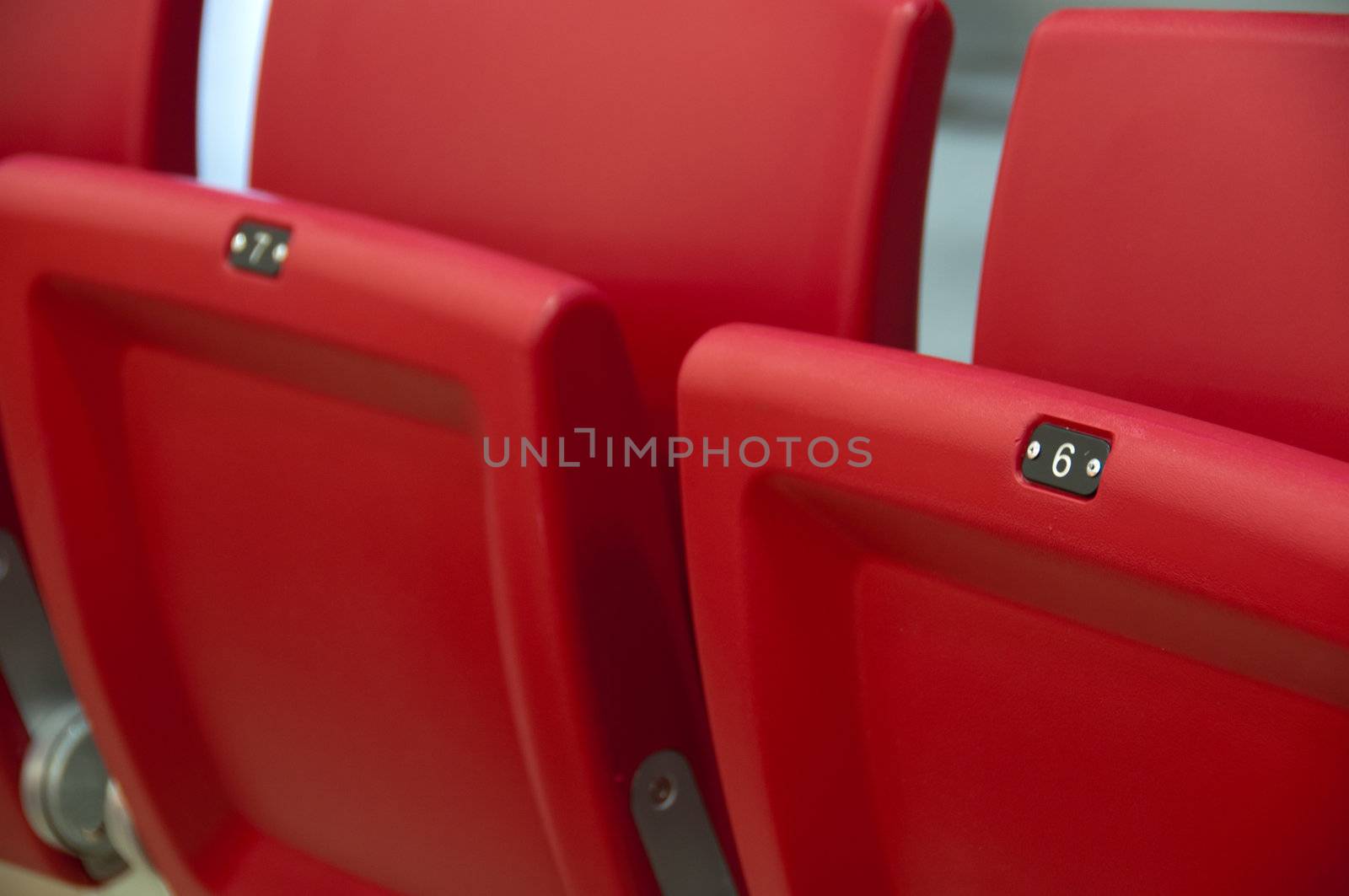 Rows of empty red seats in a football stadium