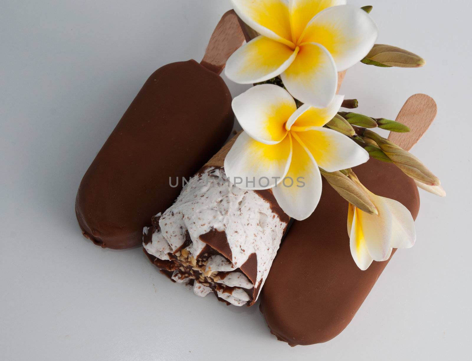 Delicious icecream and magnolia flowers on a white background .