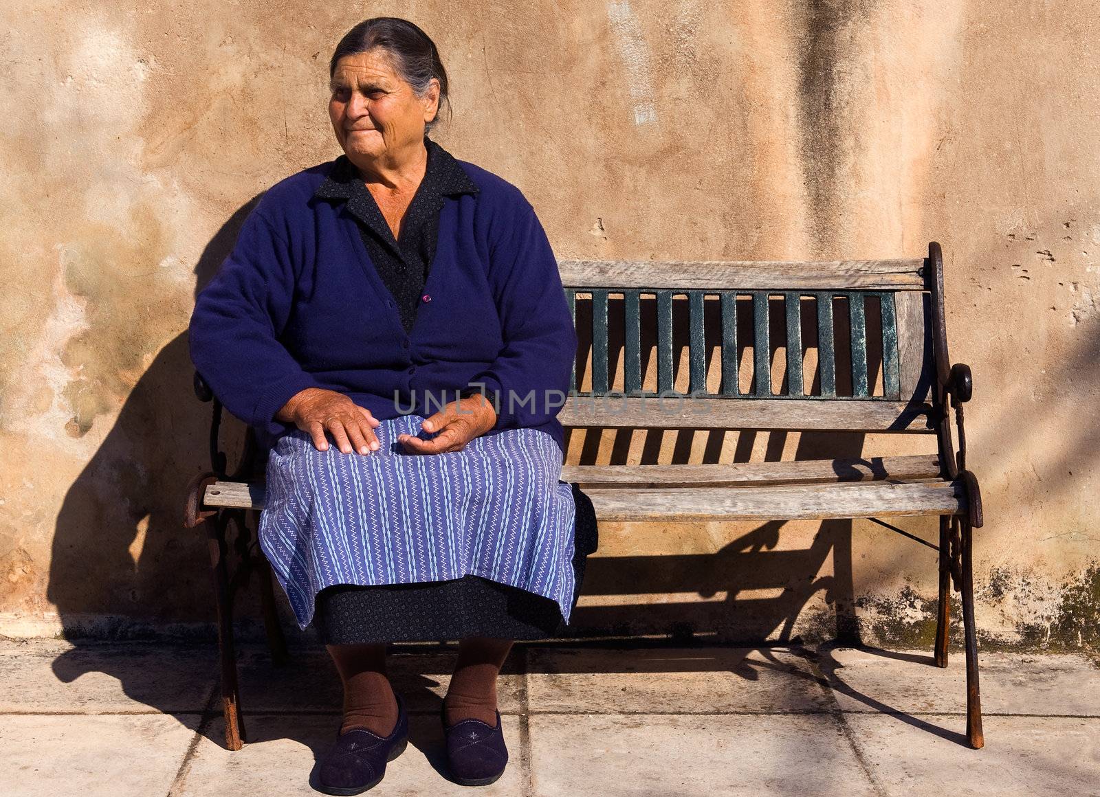 Picture of an old lady sitting on a bench in the village of Sotirianika, southern Greece