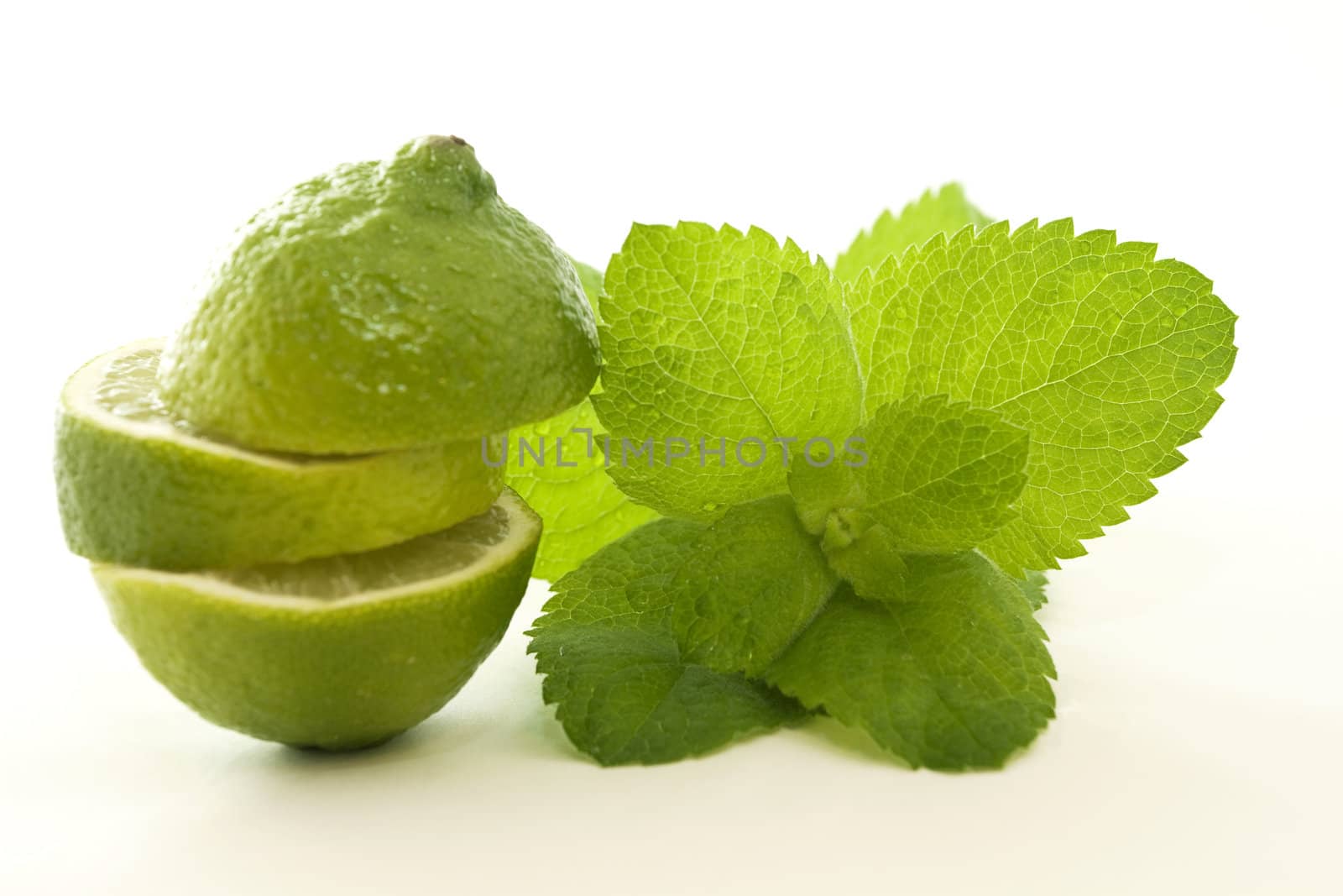 Oddly cut lime and fresh mint on a white background opens up concepts of healthy beginnings and choices.