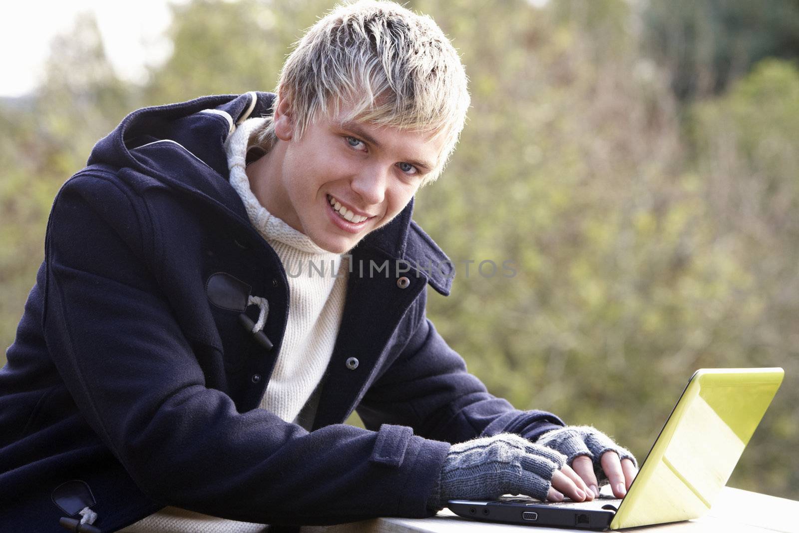 Young man with laptop computer by omg_images