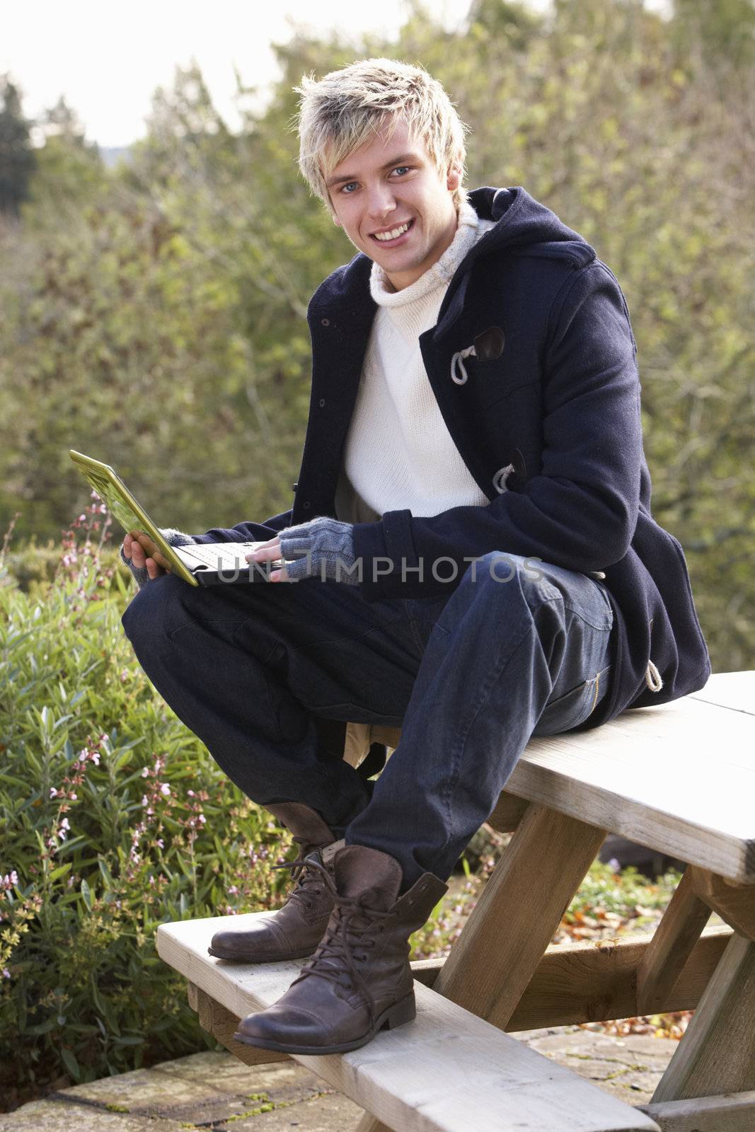 Young man with laptop computer by omg_images