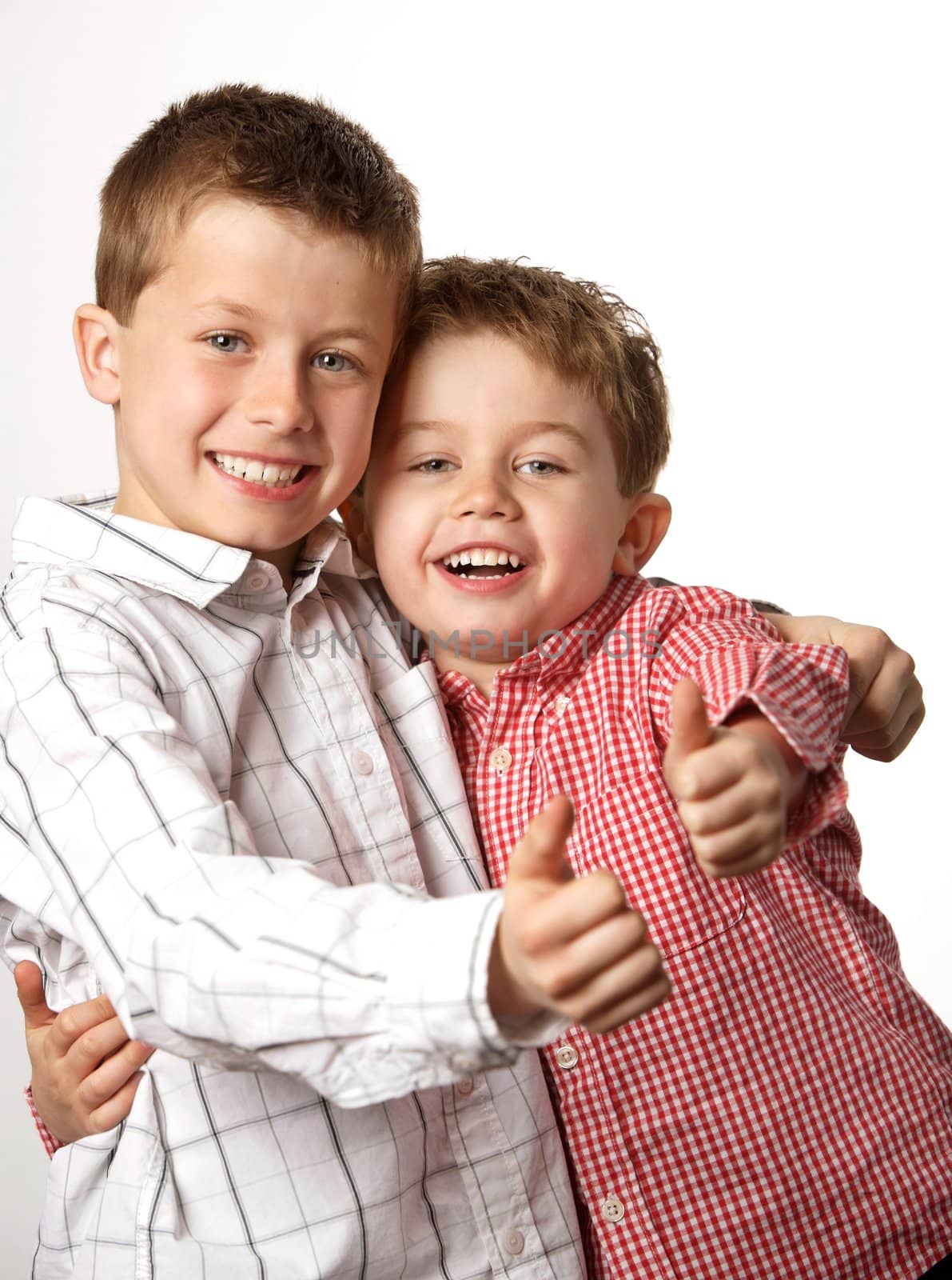 two cute young boys arm in arm with thumbs up