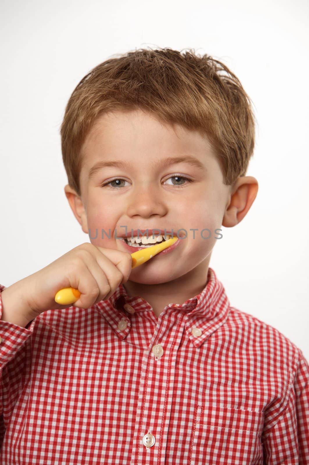 young boy brushing teeth by RainerPlendl